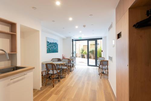 une cuisine et une salle à manger avec une table et des chaises dans l'établissement Les Suites HCR, à Paris