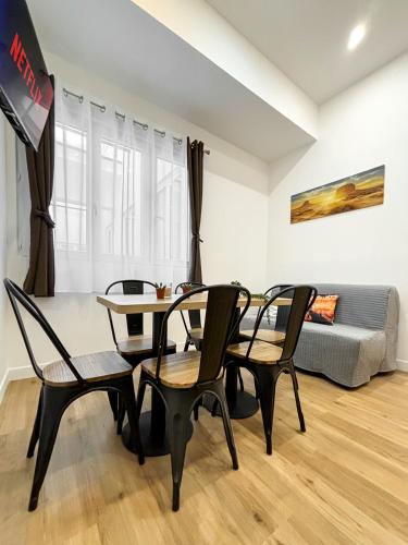 un salon avec une table, des chaises et un canapé dans l'établissement Nets Inn apartments - La Coulée Verte, à Paris