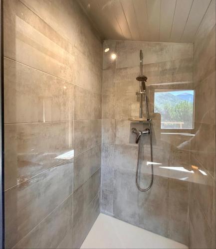 une salle de bain avec une douche avec une porte vitrée dans l'établissement La station en Drôme Provencale, à Vesc