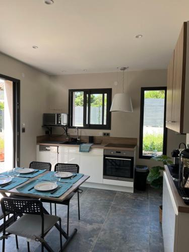 une cuisine avec une table et des chaises dans une pièce dans l'établissement Petite villa paisible, à Hyères