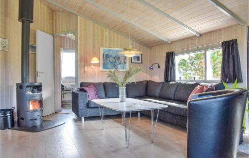 a living room with a couch and a table and a stove at Three-Bedroom Holiday Home In Hvide Sande in Hvide Sande