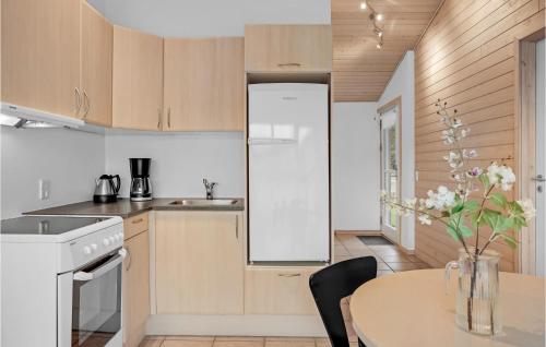 a kitchen with a table and a white refrigerator at Beautiful Home In Pandrup With Wifi in Pandrup