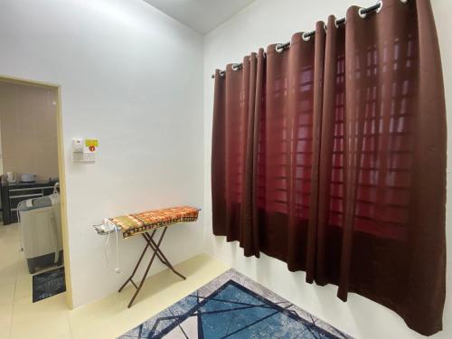 a room with a red curtain and a stool at Homestay Cikgu Ahmed Batu Kikir in Batu Kikir