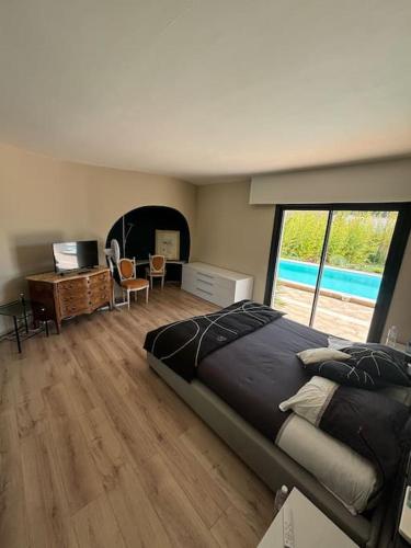 une chambre avec un grand lit et un bureau et une fenêtre dans l'établissement Magnifique villa avec piscine, à La Grande Motte