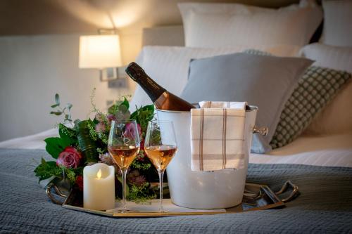 a tray with two glasses of wine and candles on a bed at LES GITES DE LA KARLSMUHLE in Haguenau