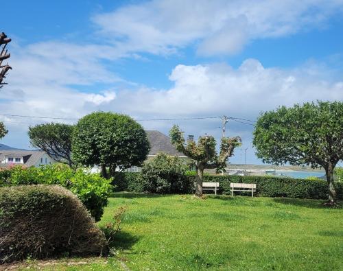 a park with a bench and trees in the grass at Génesis Valdoviño in Valdoviño
