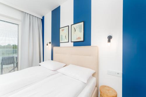 a bedroom with blue and white walls and a bed at FARO Apartamenty Polanki Aqua SPA Deluxe 4 baseny w cenie, Pools inklusive in Kołobrzeg
