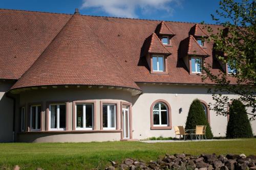 a house with a tiled roof and a lawn at LES GITES DE LA KARLSMUHLE in Haguenau