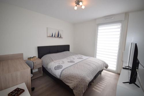 une chambre avec un lit et une télévision à écran plat dans l'établissement Appartement Sélestat, à Sélestat