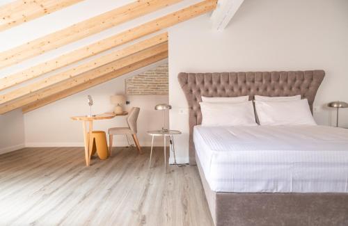 a bedroom with a bed and a table and a desk at Kosi Suites in Corfu Town
