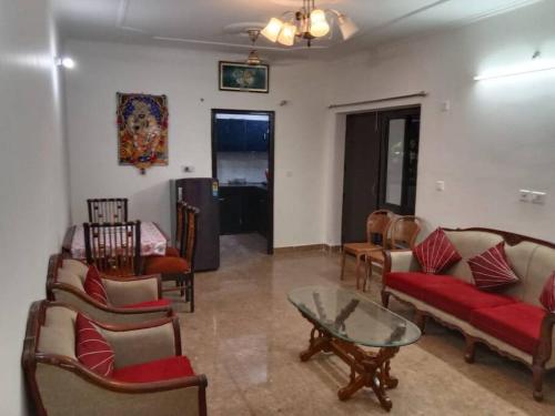 a living room with couches and chairs and a table at Chandra Lata Home's at Shri Krishna Sharnam Society in Vrindāvan