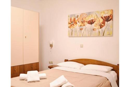 a bedroom with two beds and a painting on the wall at Manolika Studio 3 in Kithnos
