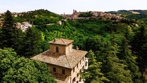 a building on the side of a hill with trees at Villa Cà Paciotti dal 1500 - Urbino e Rinascimento! in Urbino