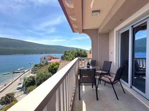 a balcony with chairs and a view of the water at Vila Jadranka Apartments in Herceg-Novi