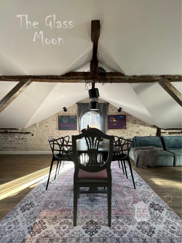 a dining room with a table and chairs on a rug at Пространства за гости Синият час - апартамент The Glass Moon in Ruse