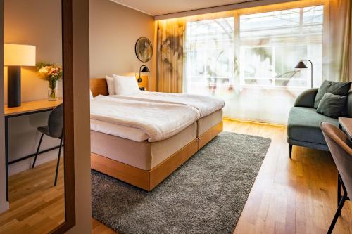 a bedroom with a bed and a couch and a window at Hyatt Place Gothenburg Central in Gothenburg