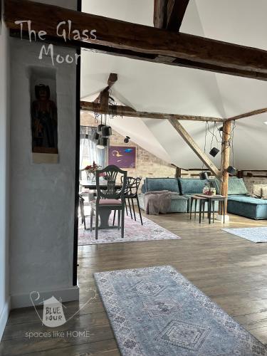 a living room with a couch and a table at Пространства за гости Синият час - апартамент The Glass Moon in Ruse