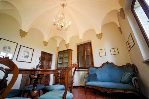 a living room with a blue couch and a chandelier at Villa Cà Paciotti dal 1500 - Urbino e Rinascimento! in Urbino