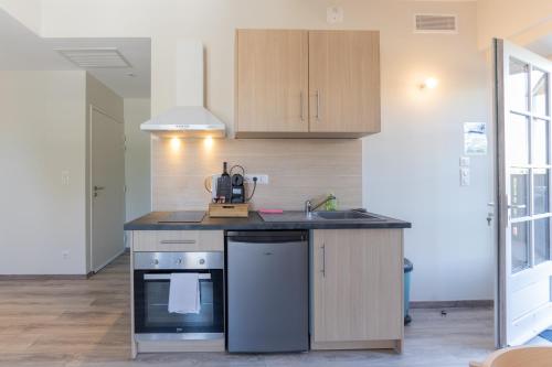 a kitchen with a sink and a stove at Viognier - logement avec jacuzzi in Ruoms