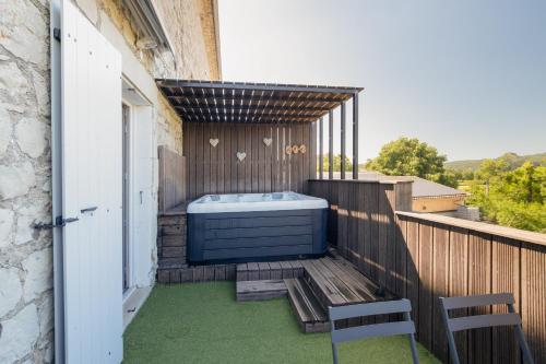 a hot tub on a balcony with two chairs at Viognier - logement avec jacuzzi in Ruoms