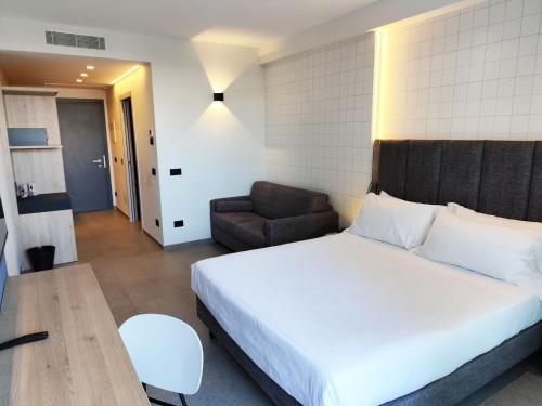 a bedroom with a bed and a chair and a couch at Hotel Sporting Riccione in Riccione