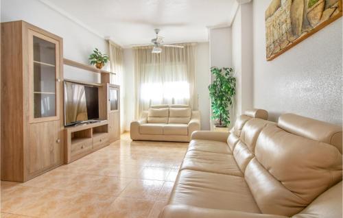 a living room with a couch and a television at Amazing Apartment In Torrevieja in Torrevieja