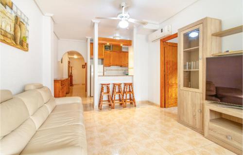 a living room with a white couch and a kitchen at Amazing Apartment In Torrevieja in Torrevieja