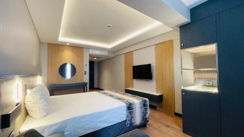 イスタンブールにあるOsmanbey Fatih Hotelのベッドとテレビがあるホテルの部屋