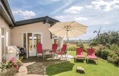 a patio with a table and chairs and an umbrella at Cozy Apartment In Karlshausen With Wifi in Karlshausen