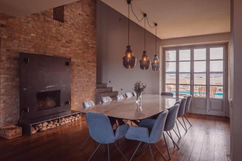 a dining room with a table and chairs and a fireplace at Scarpa Villas - Barolo Luxury Escape in Verduno