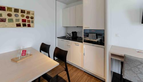 a small kitchen with a table and a counter top at Los Lorentes Apartments Bern Airport in Belp