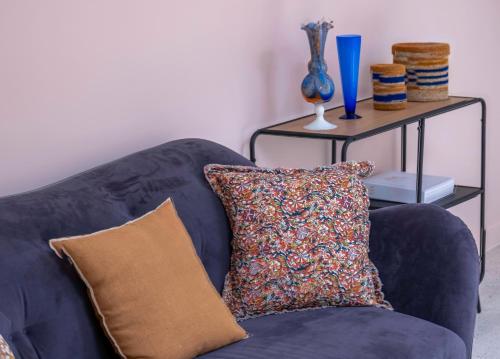 a blue couch with a pillow and a table at Clos Marcamps - Teritoria in Prignac-et-Marcamps