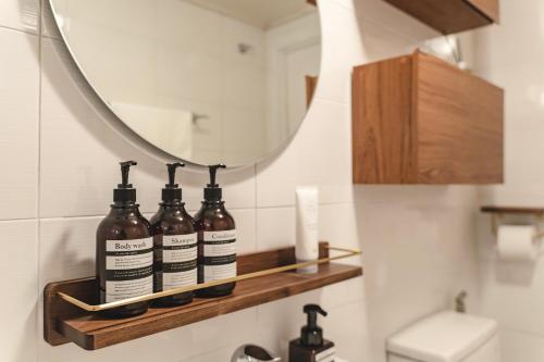 a bathroom with a shelf with four bottles on it at Emotional, 3type inteior style in Seoul