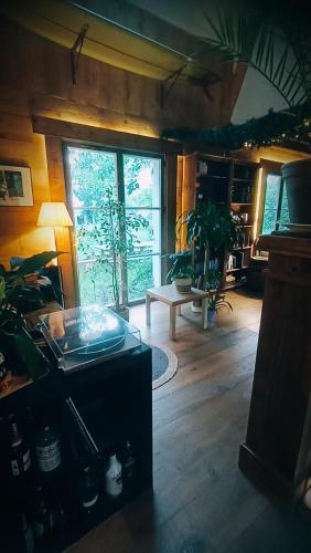un salon avec une table et une grande fenêtre dans l'établissement Studio Nature proche Paris, à Béthemont-la-Forêt