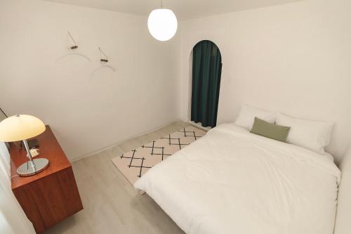 a small bedroom with a white bed and a night stand at Emotional, 3type inteior style in Seoul