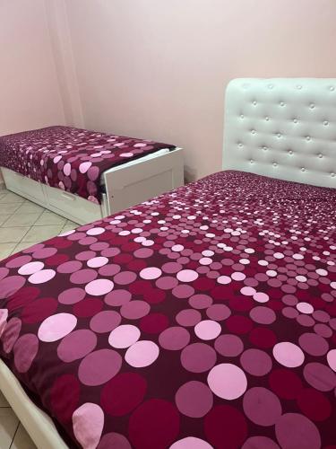 Un dormitorio con dos camas con lunares morados y rosas. en centro storico Asti Monferrato Langhe, en Asti
