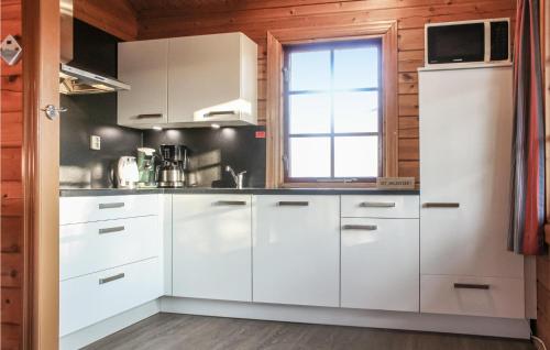a kitchen with white cabinets and a window at 3 Bedroom Cozy Home In Gramsbergen in Gramsbergen