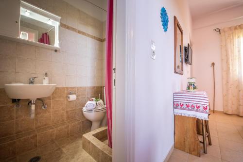 a bathroom with a toilet and a sink at Physis Studios in Vasilikos
