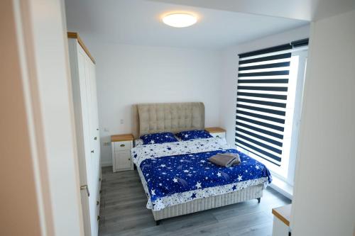 a bedroom with a bed with a blue comforter at Hunyadi Luxury Evolution in Sibiu