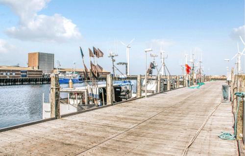 a dock with boats and windmills on the water at 2 Bedroom Gorgeous Home In Glesborg in Glesborg