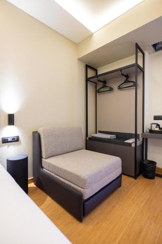 a small bedroom with a bed and a mirror at Green Boutique Hotel in Vlorë