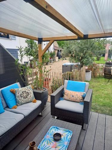 d'une terrasse avec deux chaises en osier sous une pergola. dans l'établissement Grain de folie, à Beaune