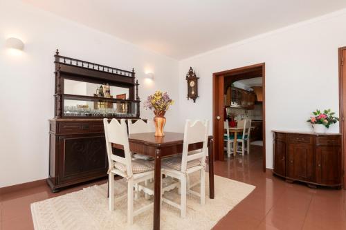 a dining room with a table and chairs and a mirror at Sines beach front Villa in Sines
