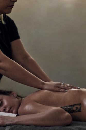 a woman sitting on a bed with a woman getting a massage at Casa Cabana Boutique Hotel & Spa - Adults Only in Faliraki