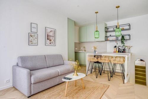 un salon avec un canapé et une cuisine dans l'établissement Bel appartement pour 6 personnes proche Champs Elysees, à Paris