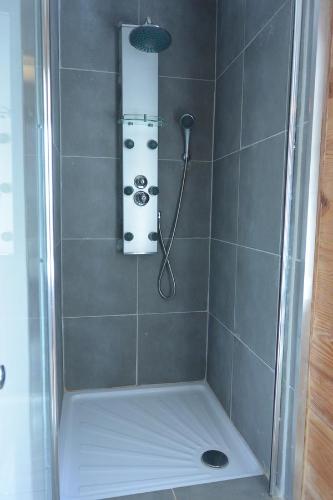a shower with a shower head in a bathroom at Aux Pays Des Sucs in Saint-Hostien