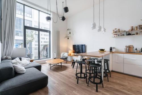 une cuisine et un salon avec un canapé et une table dans l'établissement Appartement moderne Saint-Ouen, à Saint-Ouen