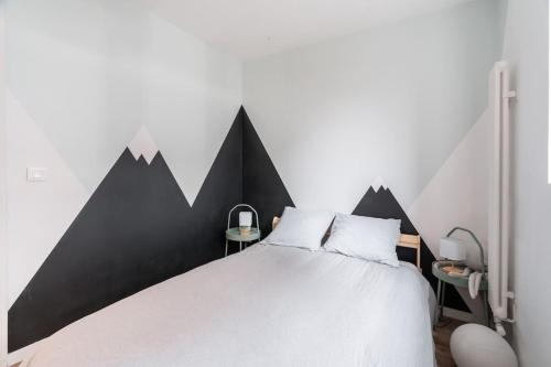 - une chambre avec un grand lit peint sur le mur et les montagnes dans l'établissement Appartement moderne Saint-Ouen, à Saint-Ouen