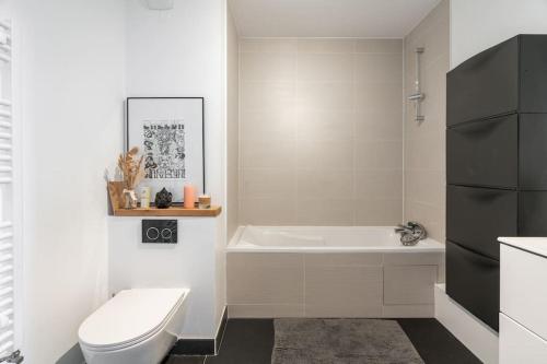 une salle de bain avec une baignoire, des toilettes et un lavabo dans l'établissement Appartement moderne Saint-Ouen, à Saint-Ouen