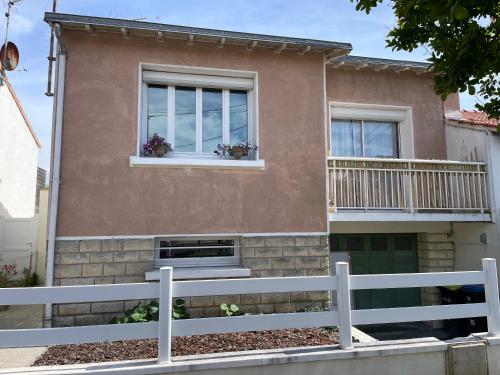 a house with two windows and a white fence at Les studios du chemins vert in La Rochelle